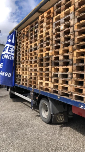 Φορτηγό φορτωμένο με στοίβες μεταχειρισμένων ξύλινων παλετών